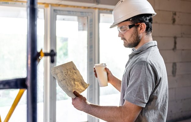 electrician-is-studying-construction-drawing-with-coffee-his-hand_169016-11717-2173522