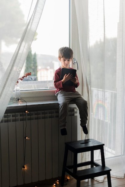 full-shot-kid-sitting-with-tablet_23-2148543133-5687298