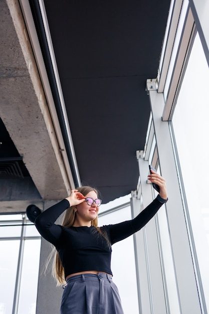 professional-adult-businesswoman-busy-texting-her-mobile-phone-wearing-shirt-trousers-standing-front-large-glass-windows_173815-11424-9670627