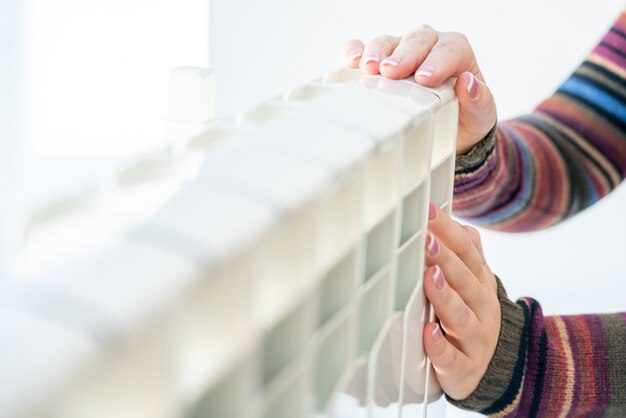 woman-touching-warm-radiator-with-both-hands_130111-1738-5314765