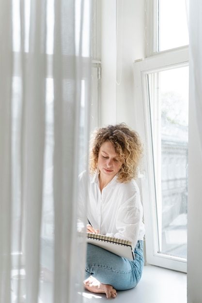 young-woman-drawing-home-near-window_23-2148982176-8487564